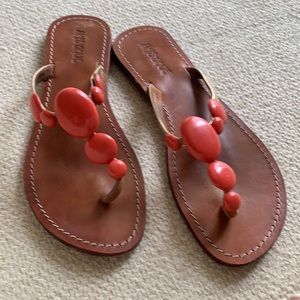 A pair of beach sandals size 9 in gold and orange stones